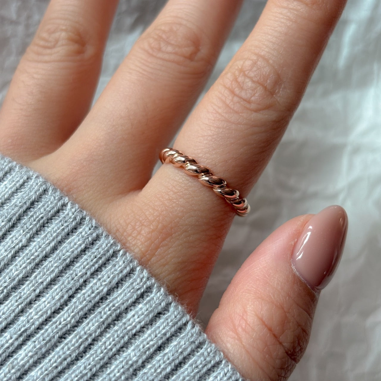 gold twist ring worn on the index finger