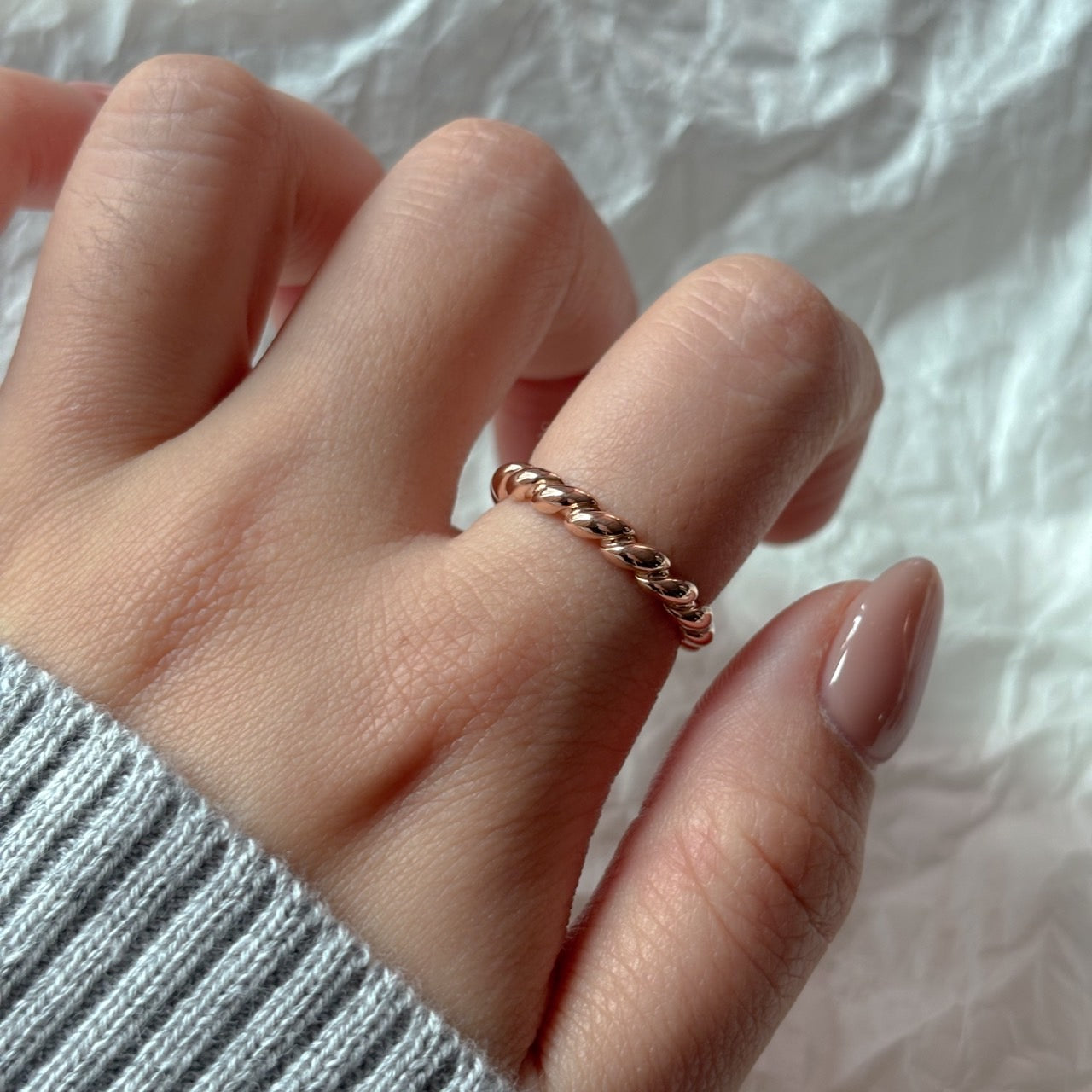 gold twist ring worn on the index finger
