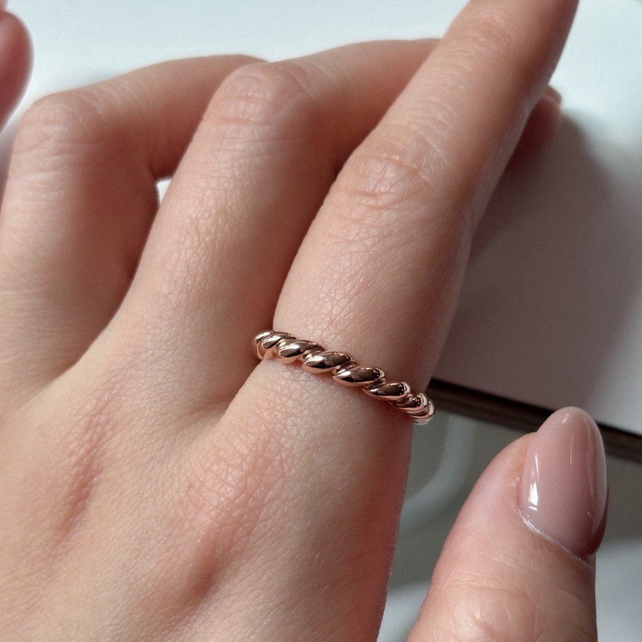 Gold twist ring on index finger