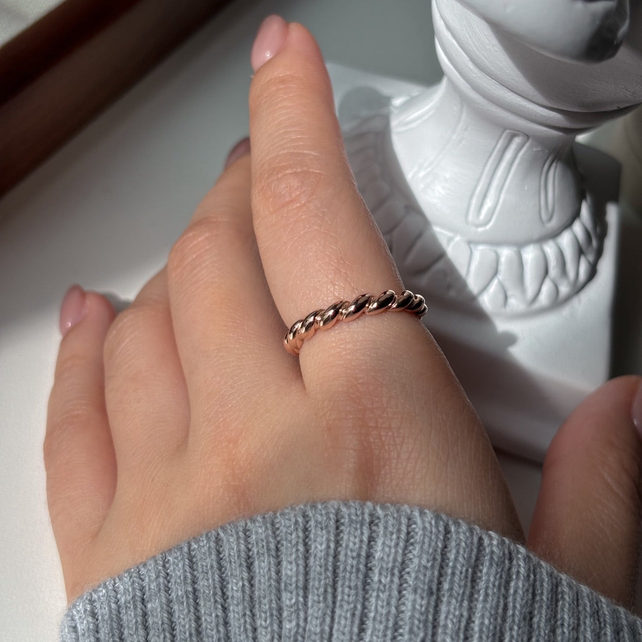 gold twist ring worn on the index finger