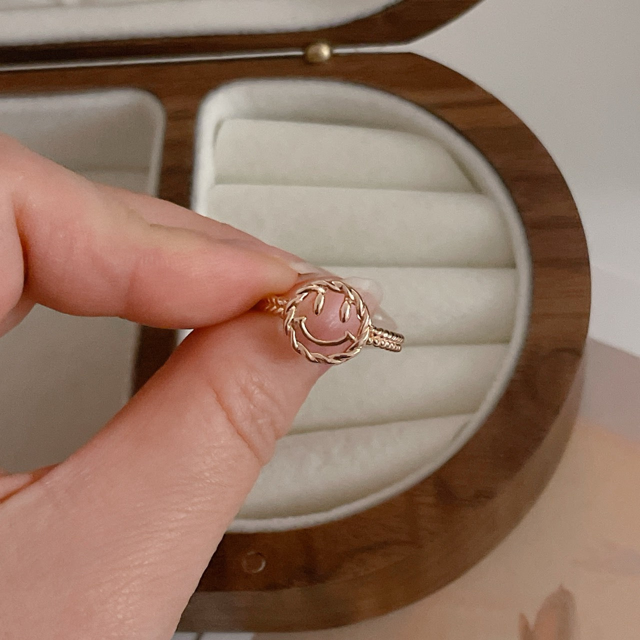 Happy Face Ring being held in hand.